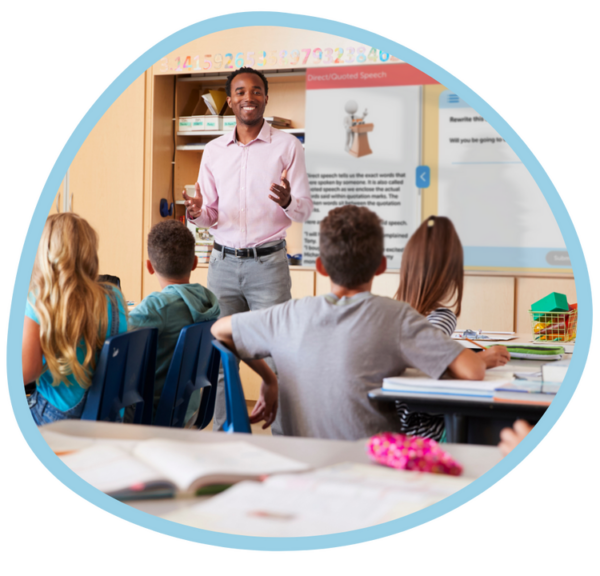 Teacher leading a reading lesson in a classroom with students seated.