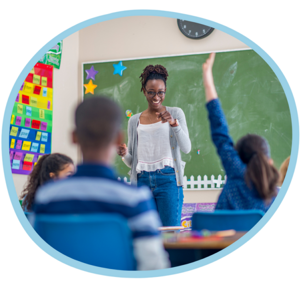 Teacher standing at the front of a classroom with students attentively listening and participating.