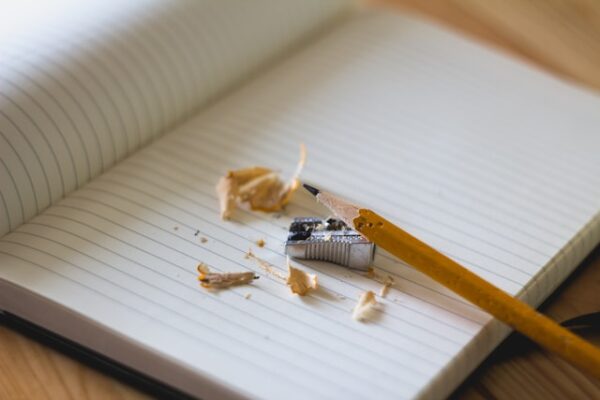 Pencil and pencil sharpener on open notebook