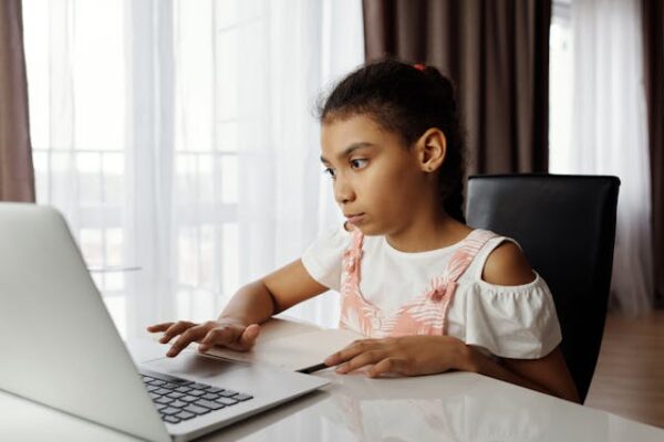 young girl sitting in front of laptop